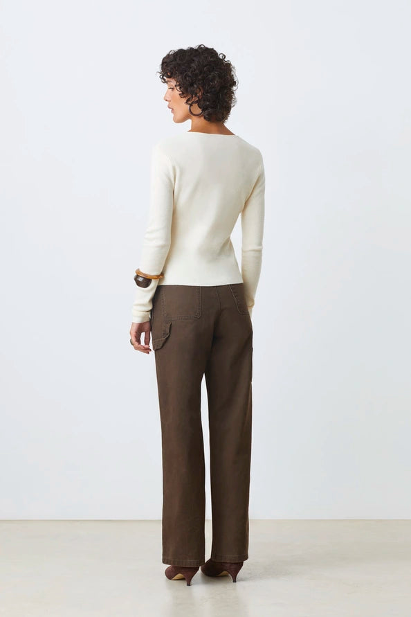 Back view of woman wearing a rouched in the buttons cream long sleeve knitted top