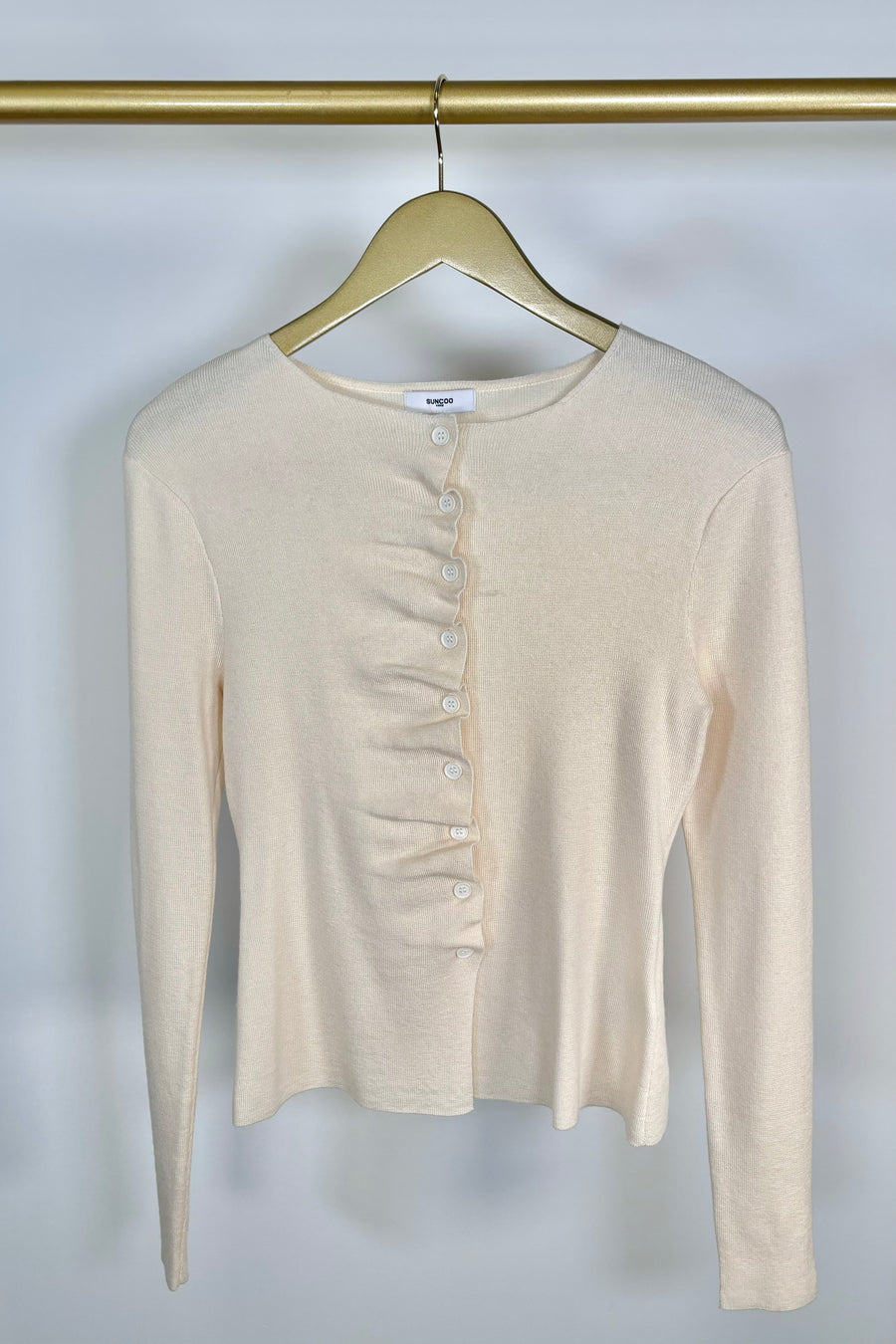 Front view of a rouched in the buttons cream long sleeve knitted top