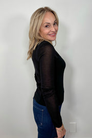 Side view of woman wearing a Black layered long sleeve top with sheer sleeves