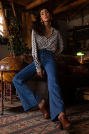 Front view of woman wearing a button up blouse with zig zag black stipes