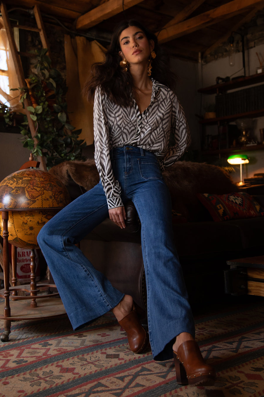 Front view of woman wearing a button up blouse with zig zag black stipes