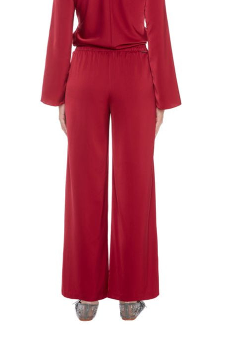 Back view of woman wearing a satin red pant