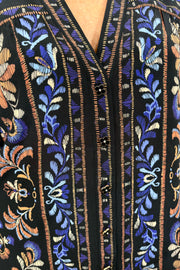 close up of woman wearing a v-neck black silk printed long sleeve blouse