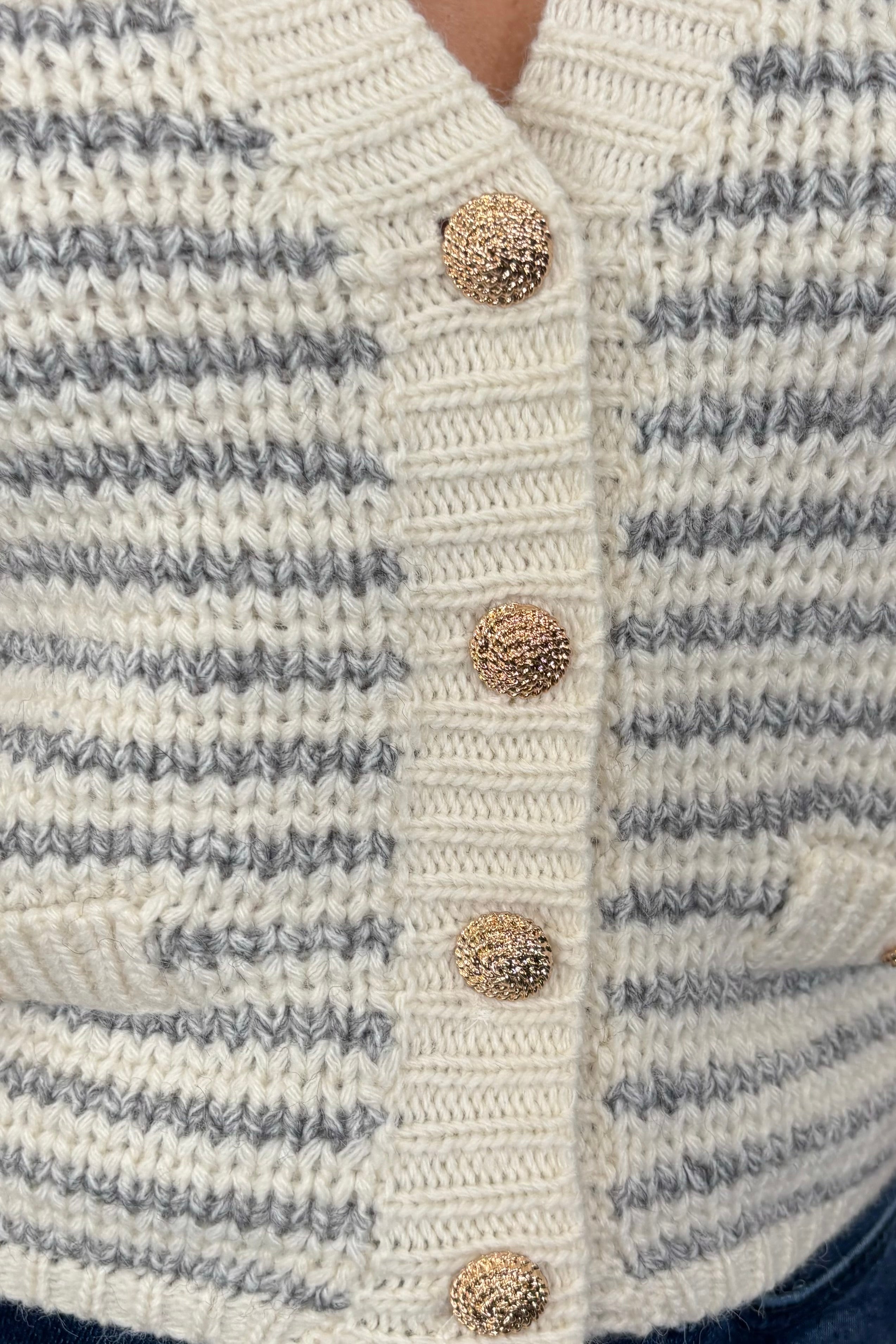 Close-up of the buttons of a knitted striped vest
