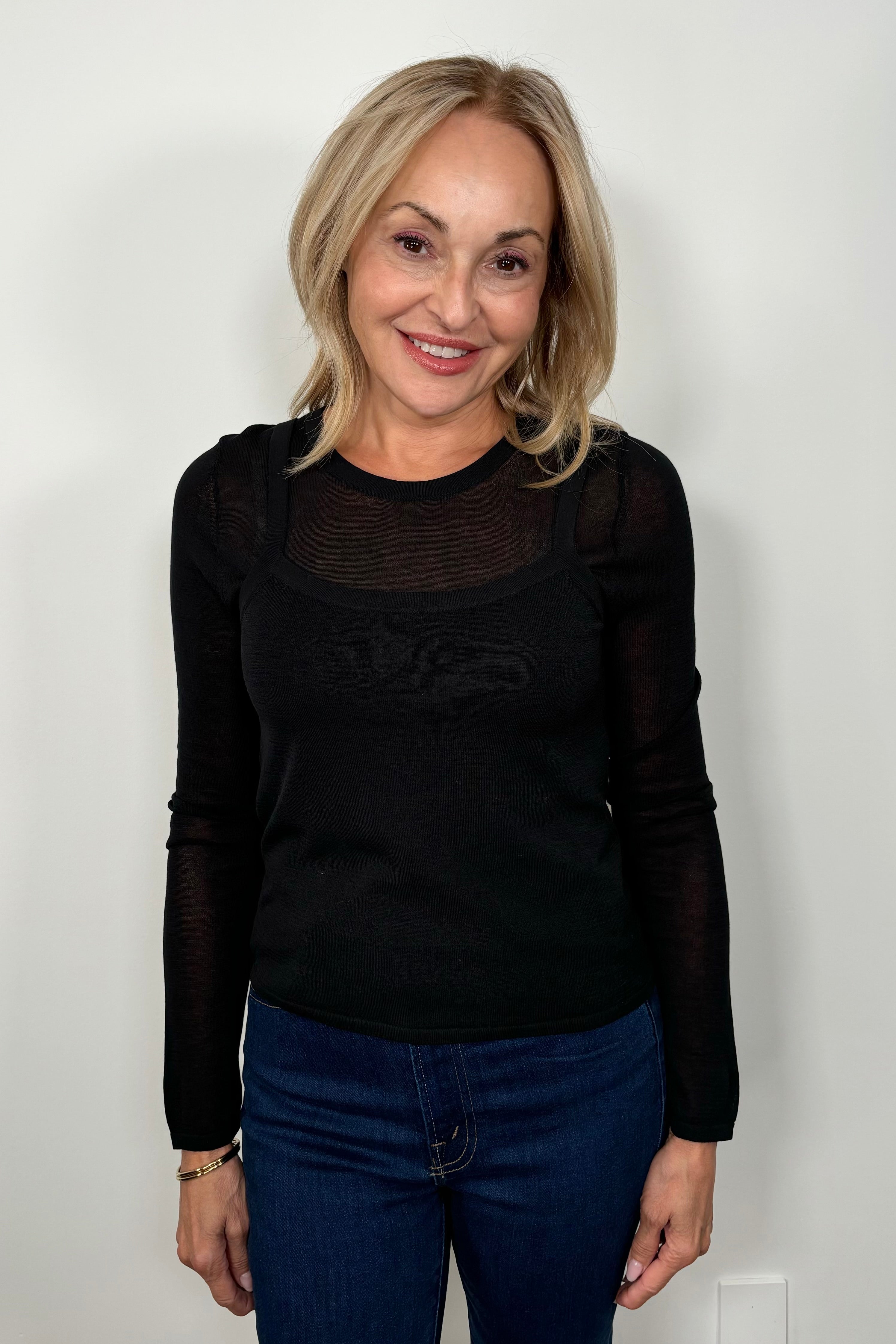 Front view of woman wearing a Black layered long sleeve top with sheer sleeves