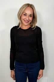 Front view of woman wearing a Black layered long sleeve top with sheer sleeves