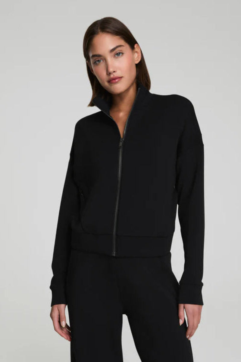 Woman wearing a black jacket on a gray background