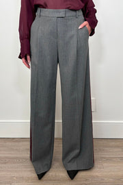 Front view of woman wearing a gray pinstripe wide leg pant with a burgundy line down the leg