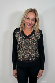 Front view of woman wearing a patterned v-neck black sweater