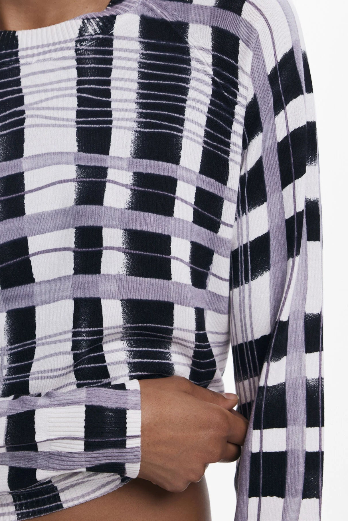 Close-up of a light-weight plaid black, white and lilac sweater's pattern