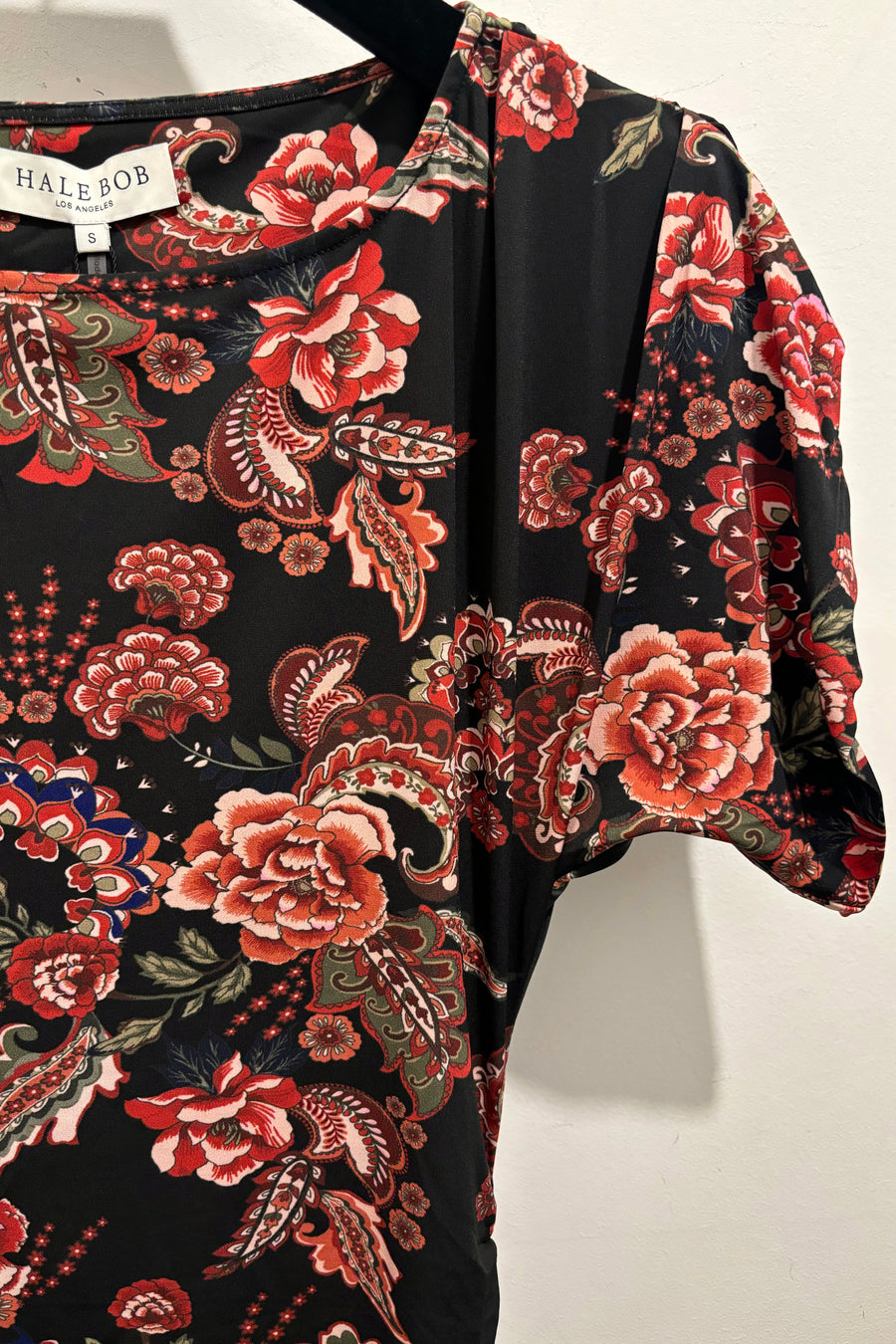 Close up view of a midi dress with floral and paisley pattern