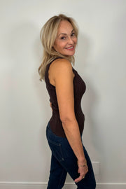Side facing woman wearing a brown squared neck knitted tank top.