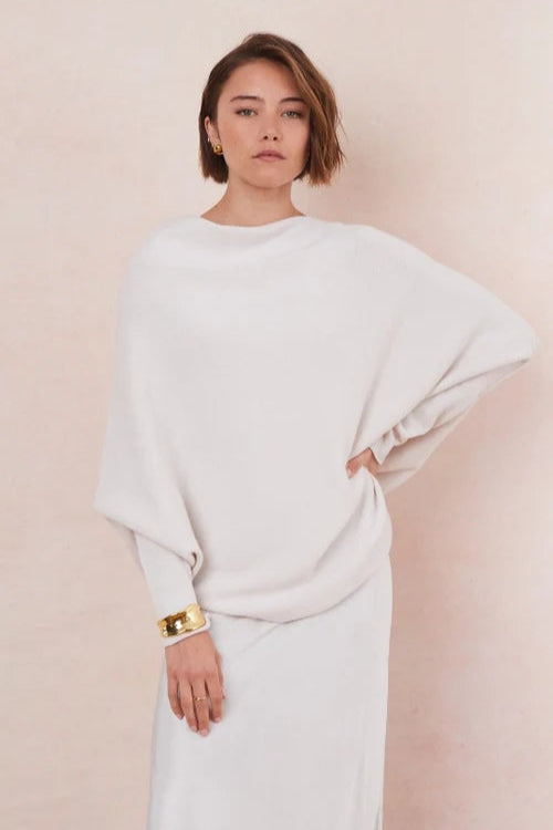 Woman wearing a white off the shoulder sweater