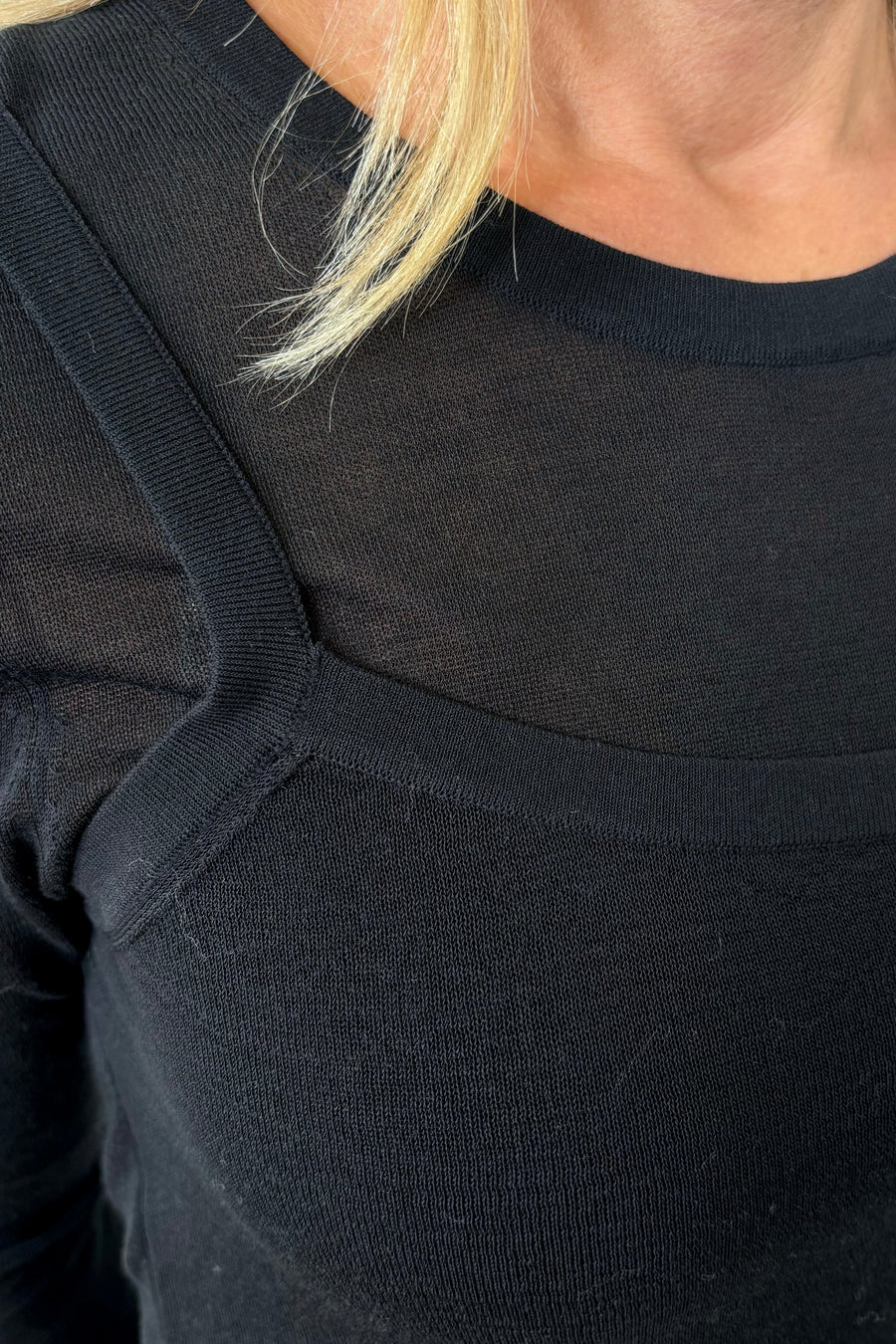 Close-up of the right shoulder of a Black layered long sleeve top with sheer sleeves