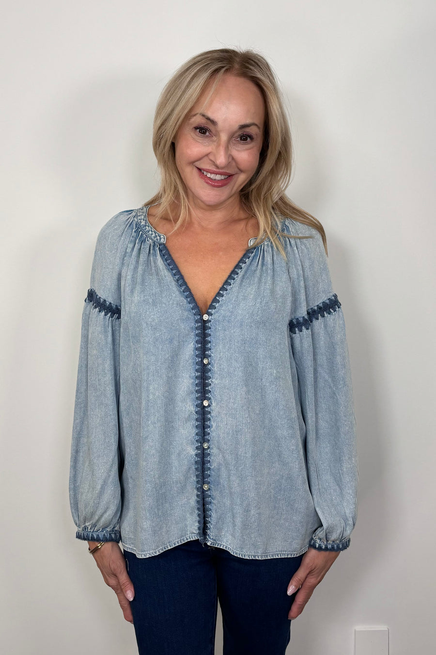 Front view of woman wearing a blue tencel blouse with stitch detailing