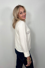 side view of woman wearing a cashmere long sleeve white shirt