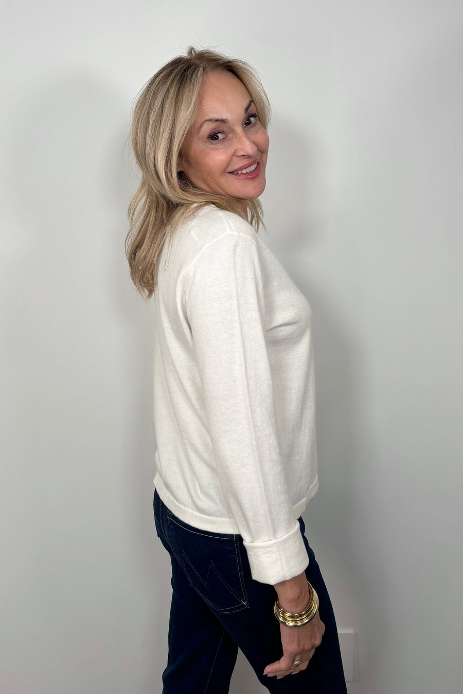 side view of woman wearing a cashmere long sleeve white shirt