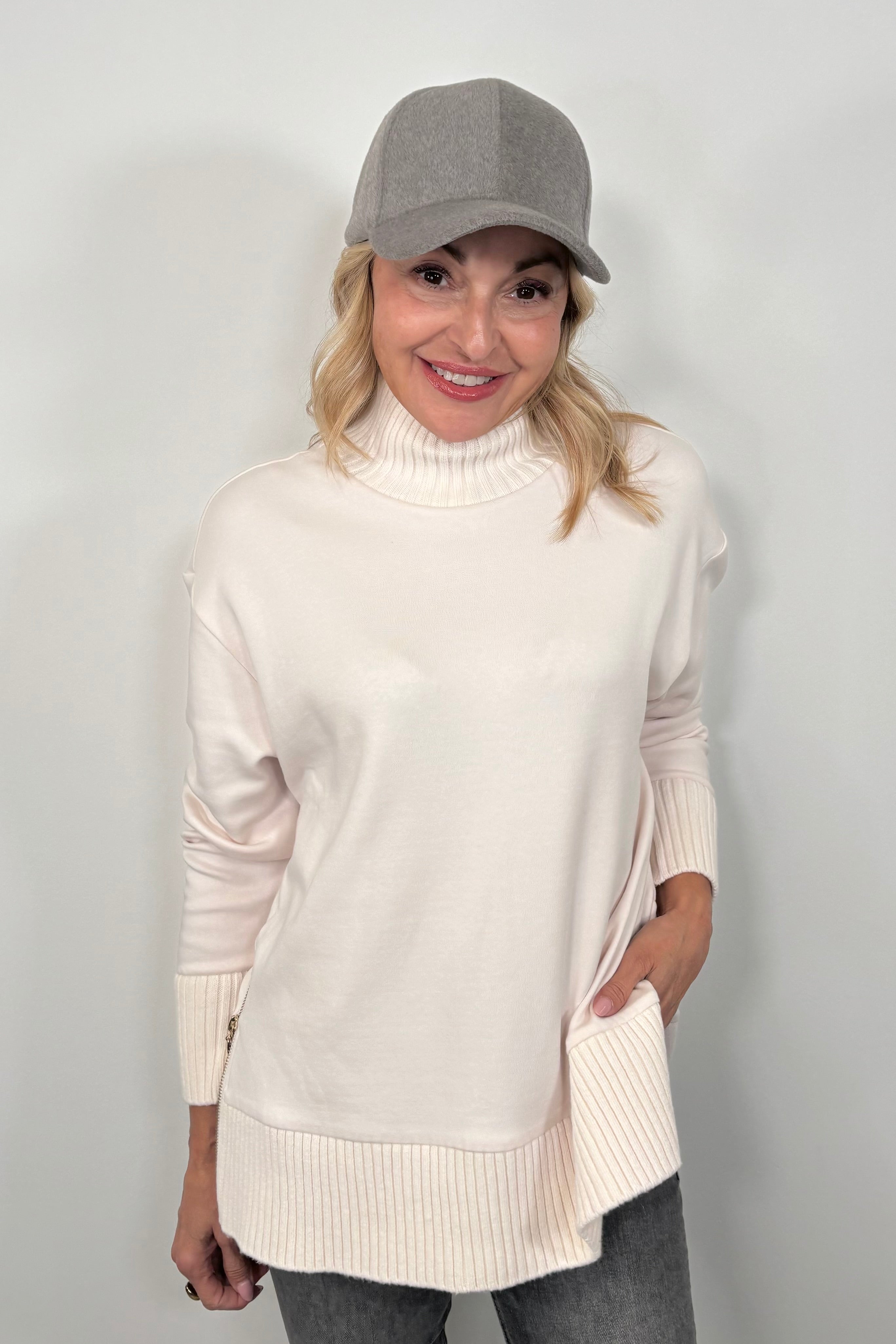 woman wearing a white mock neck sweatshirt