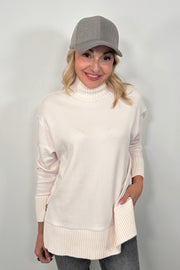 woman wearing a white mock neck sweatshirt