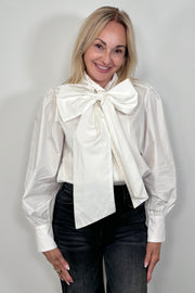 Front view of woman wearing a white poplin shirt with a Bow in the neck tucked in