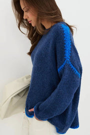 Woman wearing a blue sweater against a white background