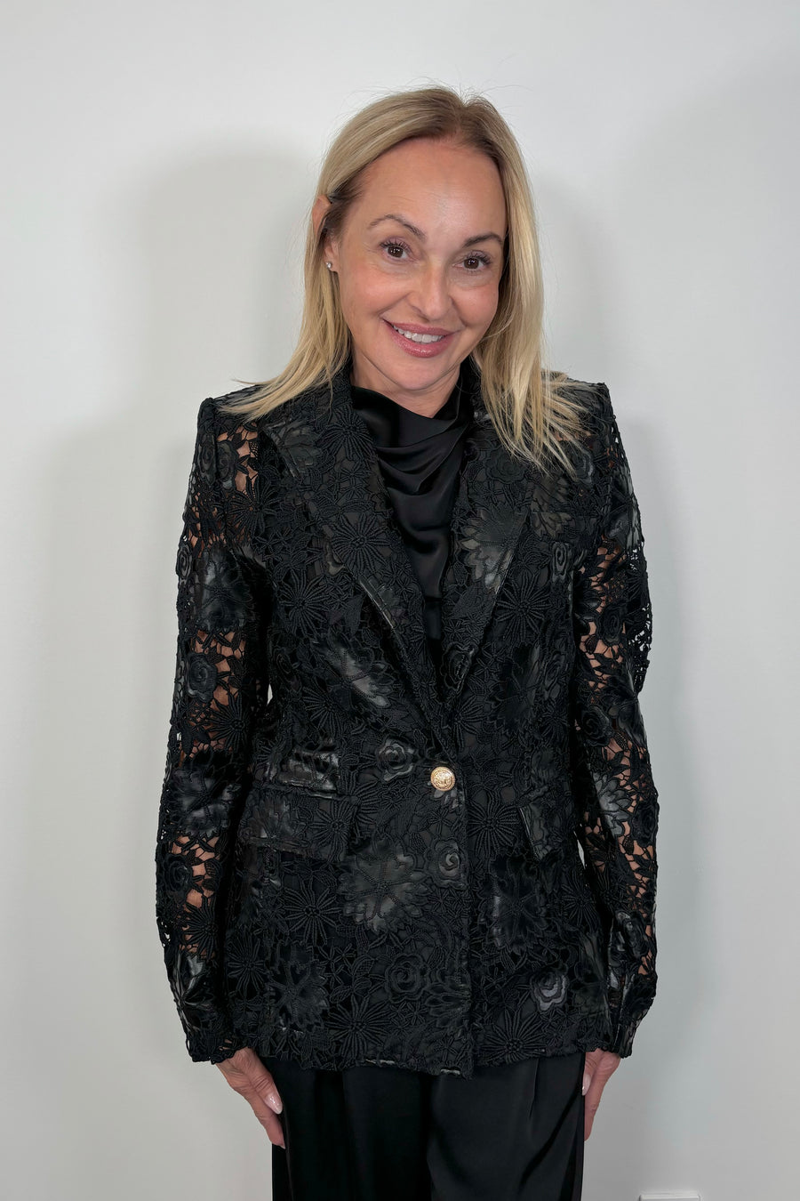 Front view of woman wearing a vegan leather, lace blazer