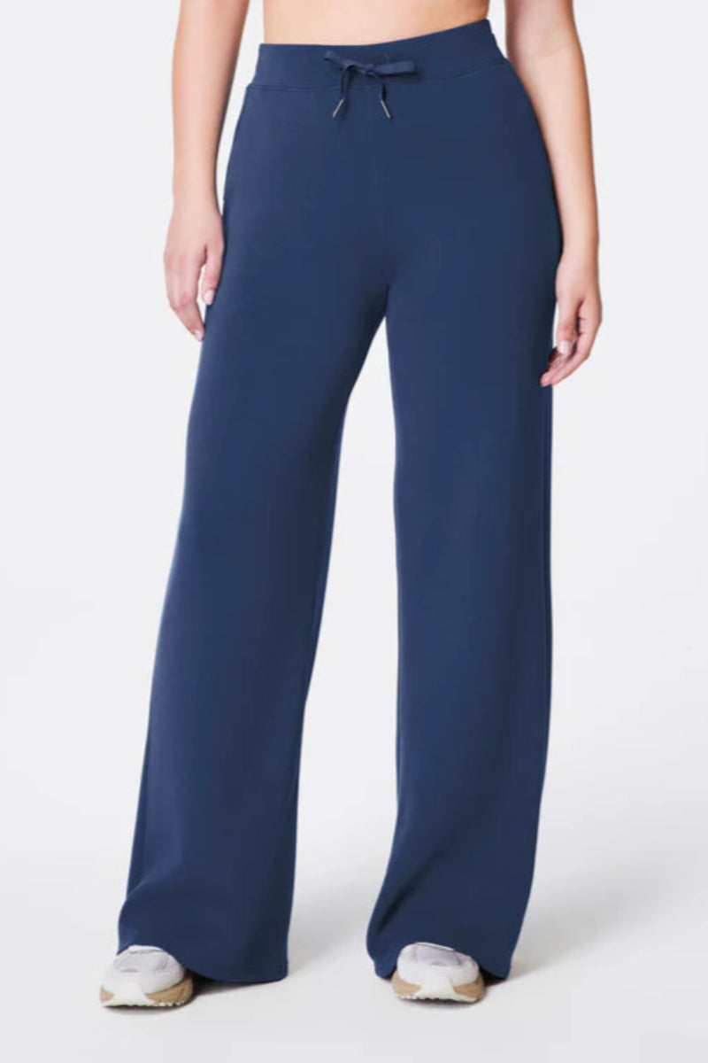 Navy blue wide-leg pants worn by a person on a white background