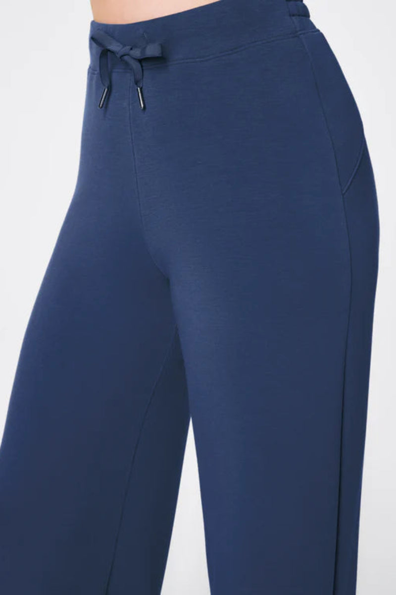 Navy blue pants with a drawstring on a white background