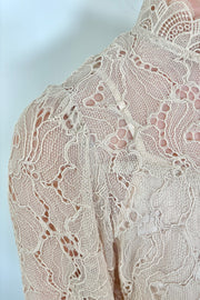 Close-up of beige lace fabric with a floral pattern