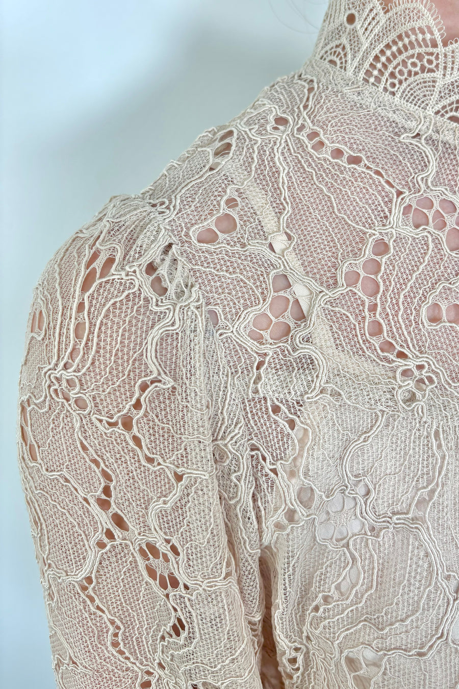 Close-up of beige lace fabric with a floral pattern
