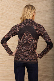 Woman wearing a paterned black mesh top against a wooden panel background