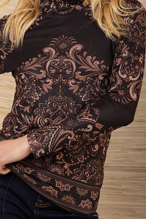 Woman wearing a black patterned mesh turtleneck long-sleeve top against a wooden background