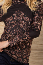 Woman wearing a black patterned mesh turtleneck long-sleeve top against a wooden background