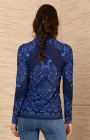 back view of a woman wearing a blue patterned turtleneck top