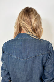Back view of woman wearing a western snap blue shirt