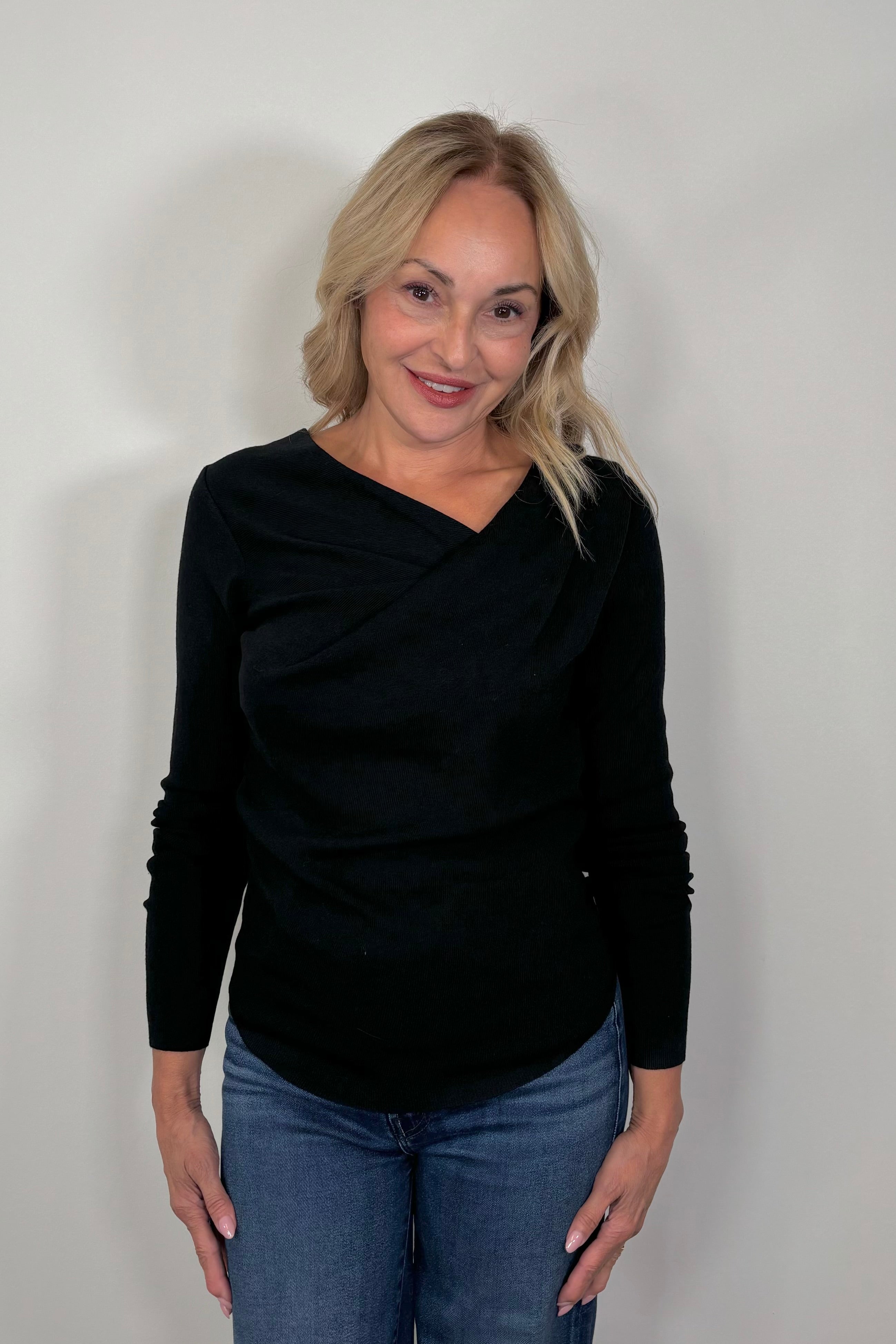 woman wearing black drape neck knit top