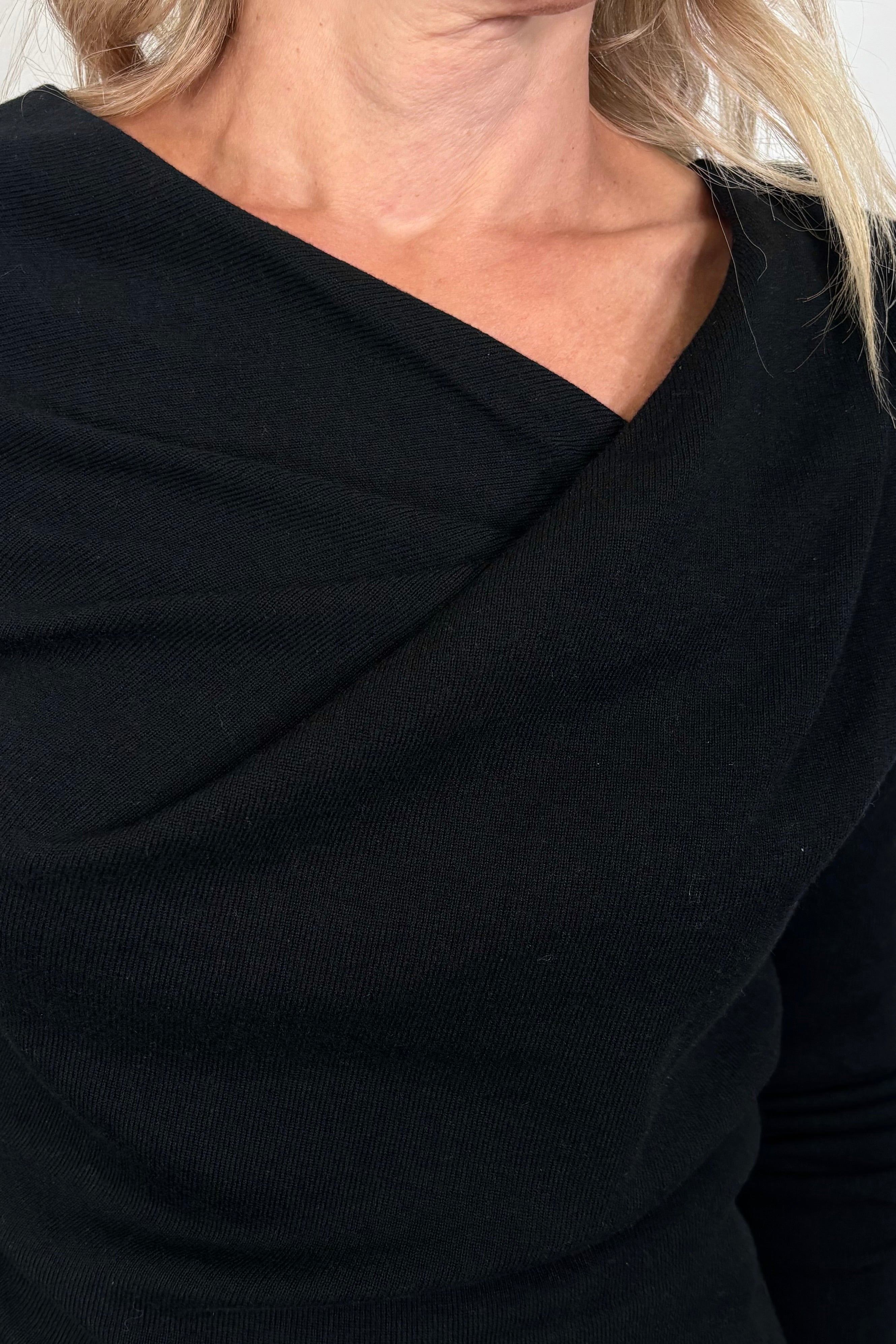 close-up of a black drape neck knit top