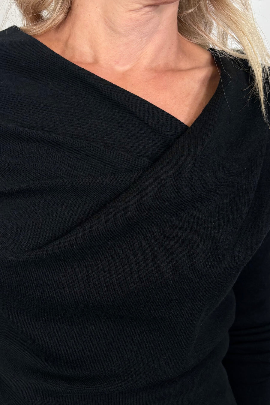 close-up of a black drape neck knit top