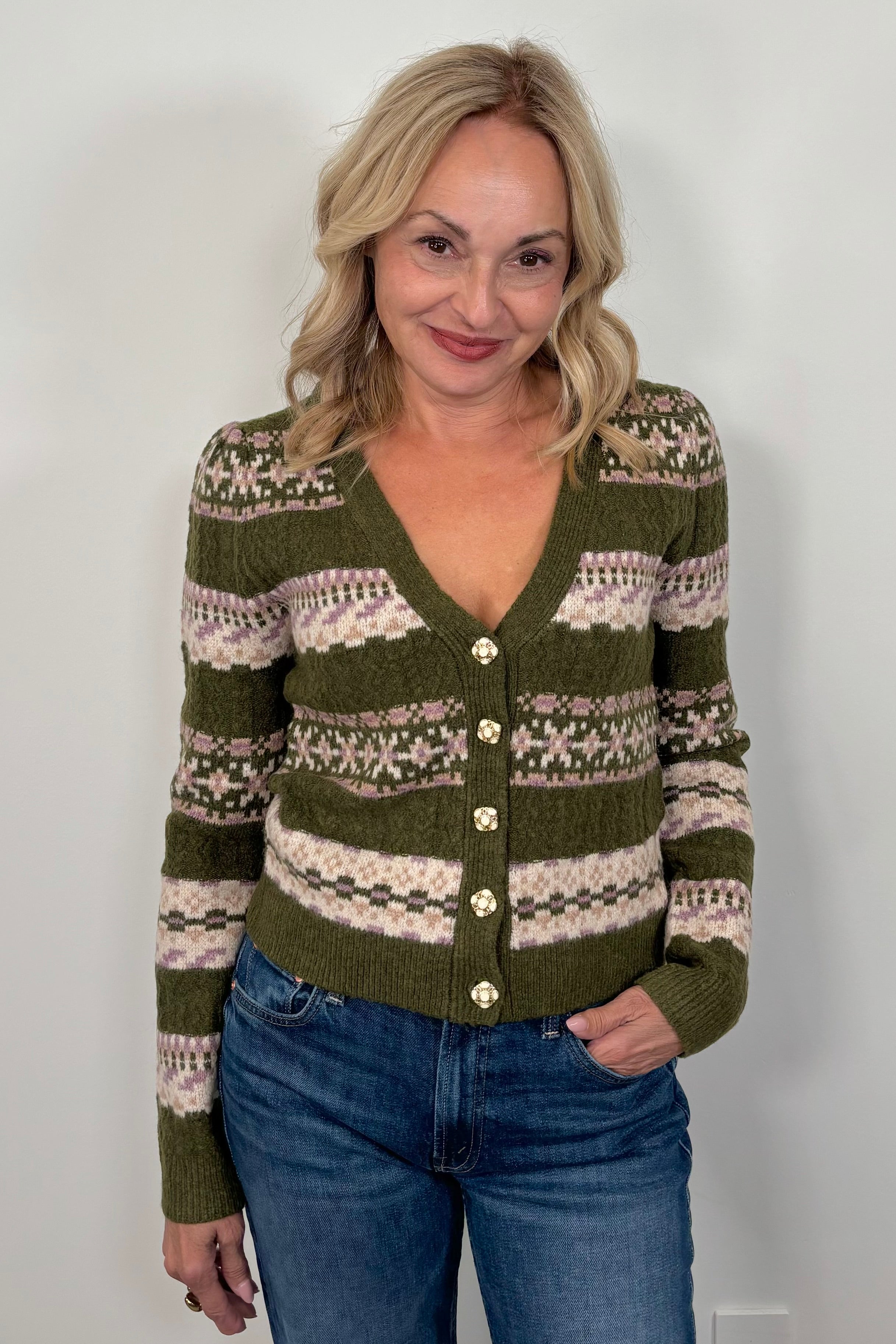 Woman wearing a green patterned cardigan against a white background