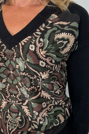 Close-up of a v-neck patterned black sweater