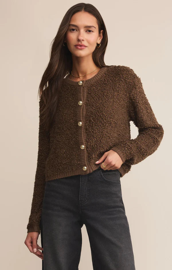 Woman wearing a brown textured cardigan against a beige background