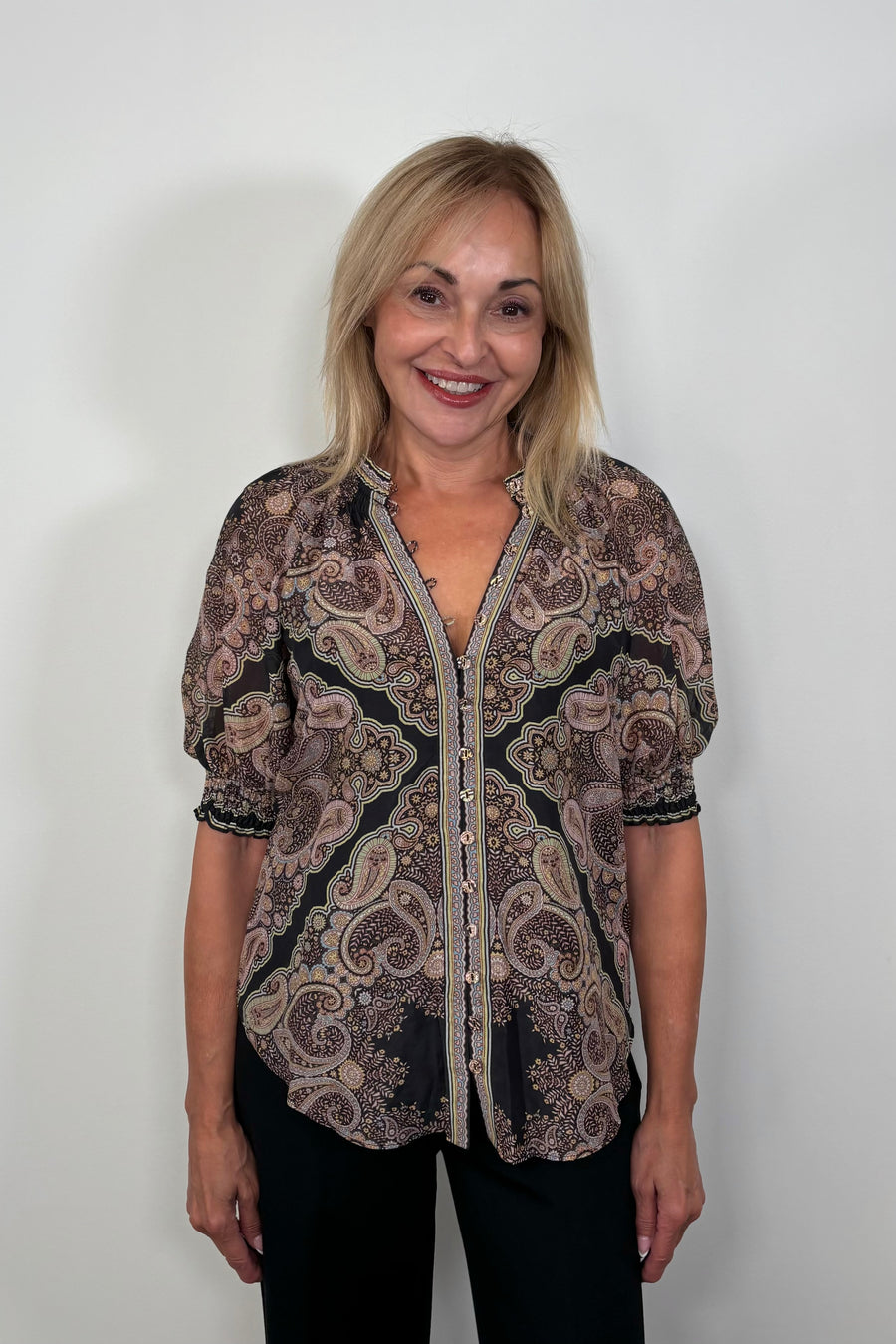 Front facing woman wearing a cotton and silk blend black half sleeve top with a light brown pattern