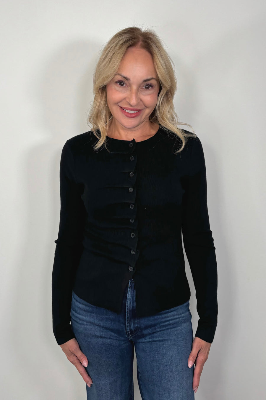 woman wearing a black rouched front knit top