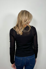 Back view of woman wearing a Black layered long sleeve top with sheer sleeves
