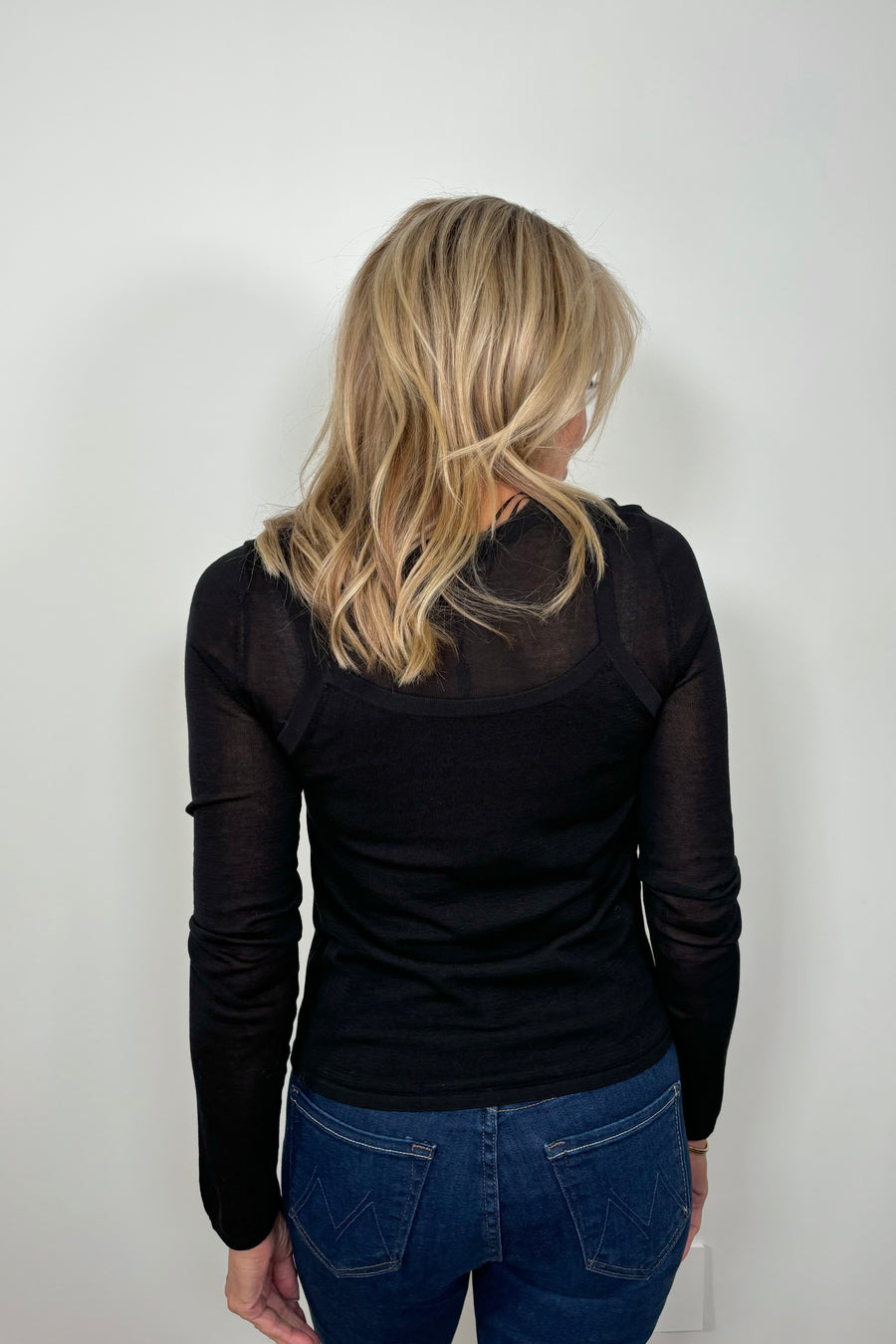 Back view of woman wearing a Black layered long sleeve top with sheer sleeves