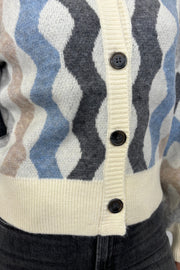 Close up view of woman wearing a cardigan with blouson sleeved and a multicoloured waive design