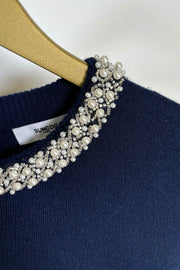 Zoom in of the neckline of a navy knitted top