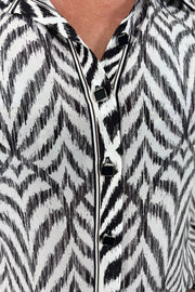 Close up view of woman wearing a Button up blouse with zig zag black stipes
