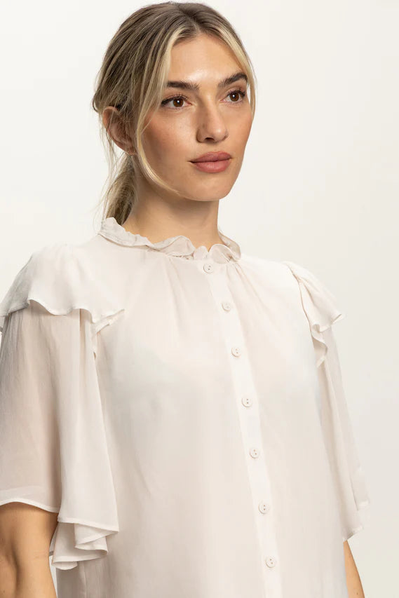 Close up of woman wearing an oat coloured light blouse