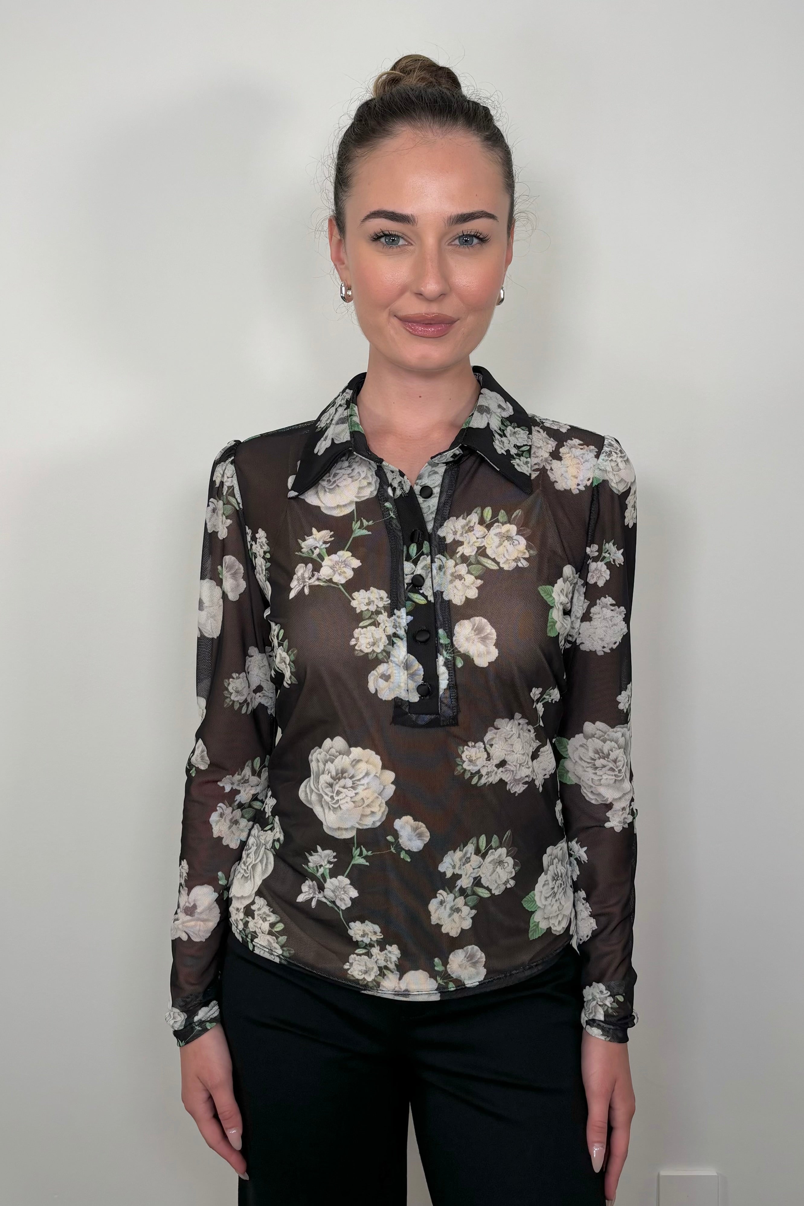 Woman wearing a black mesh floral shirt